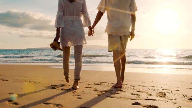 Sunset Walk on a Luxury Beach. Happy Retired Couple on Tropical Vacation.