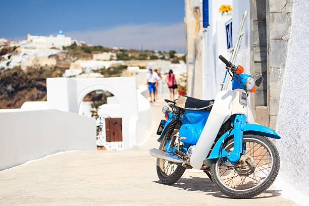 Blue - white moped standing on a walkway in Fira (Santorini, Island, Cyclades, Greece).