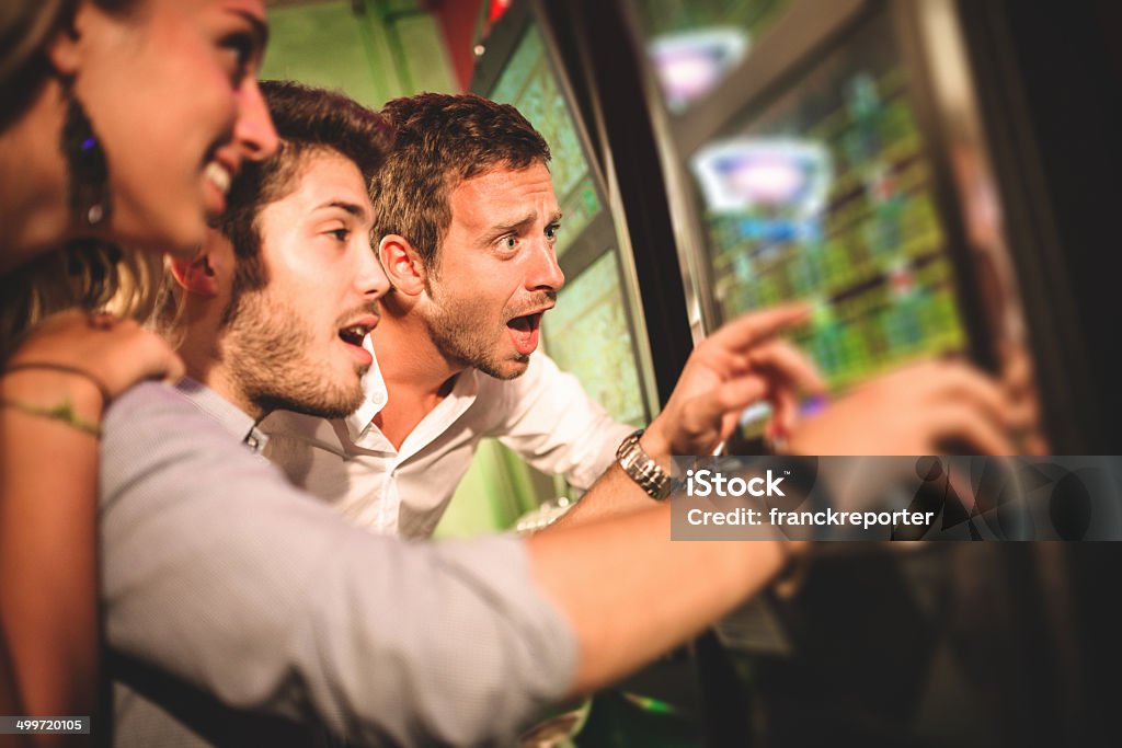 Amis jouant au casino - Photo de Machine à sous libre de droits