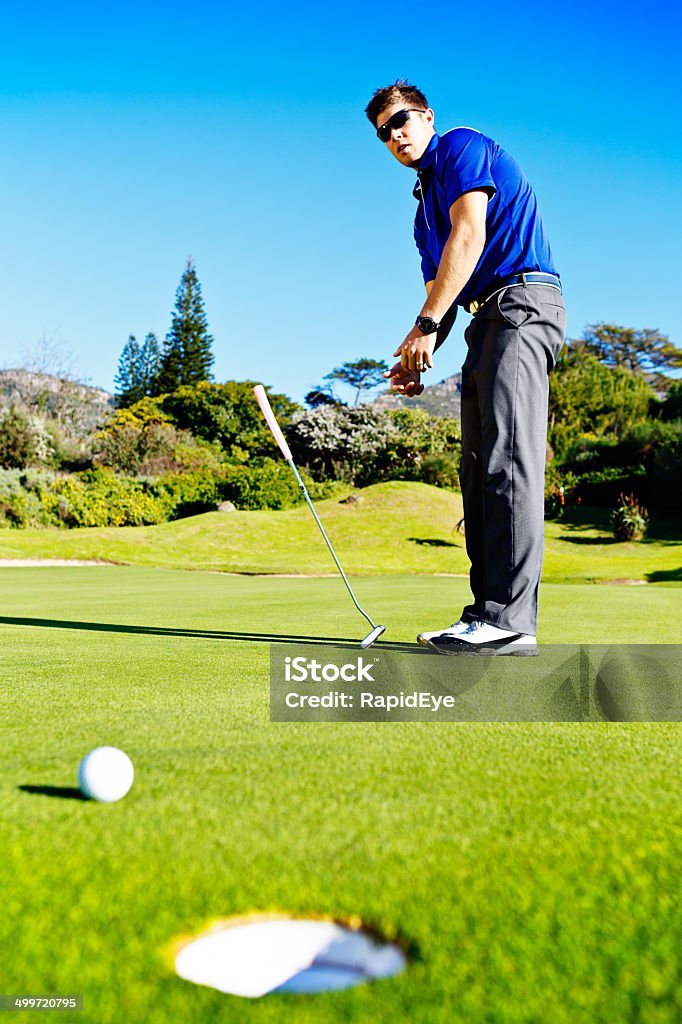 Poor performance! Golfer misses putt and throws down club angrily A young golfer who has just missed a putt throws down his club angrily. Golf can be a frustrating game but this is bad behavior! 20-29 Years Stock Photo