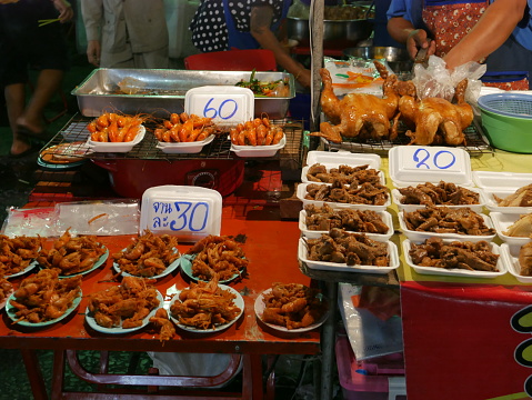 Bangkok, Thailand – November 27, 2015 - Temple fair in Wat Saket, Bangkok. Vendors sell food in the fair area. Some people buy food. Some walk around the area. It is common in Thailand that some locals buy food from street food vendors.