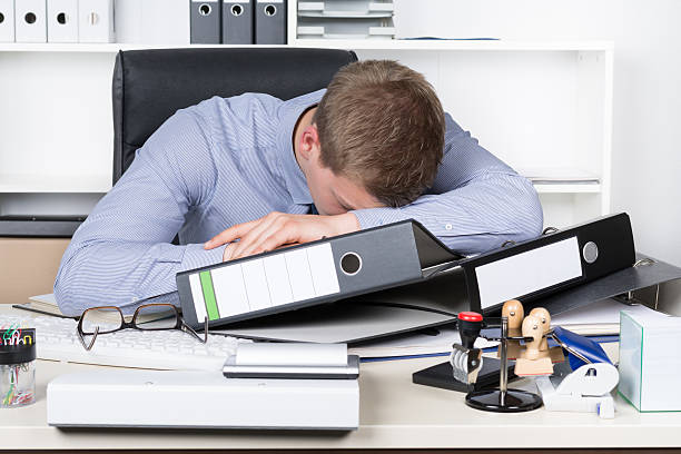 istock Young exhausted man is lying on the desk in office 499721001
