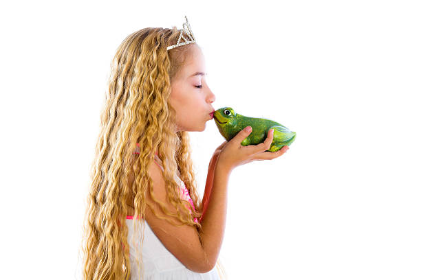 istock blond princess girl kissing a frog green toad 499727470