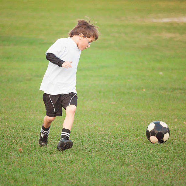 istock Kid playing football 499734983
