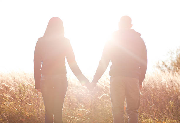 istock young couple holding hands. In Nature sunrise 499736515