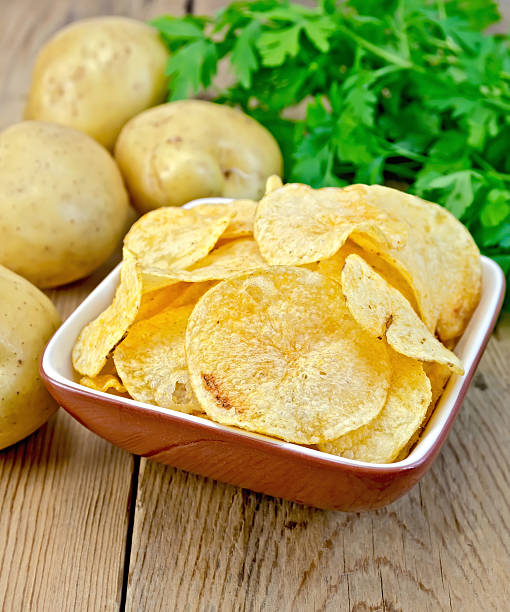 istock Chips in a bowl with a potato on the board 499739491