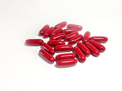 Vitamin supplement capsules closeup on a white background