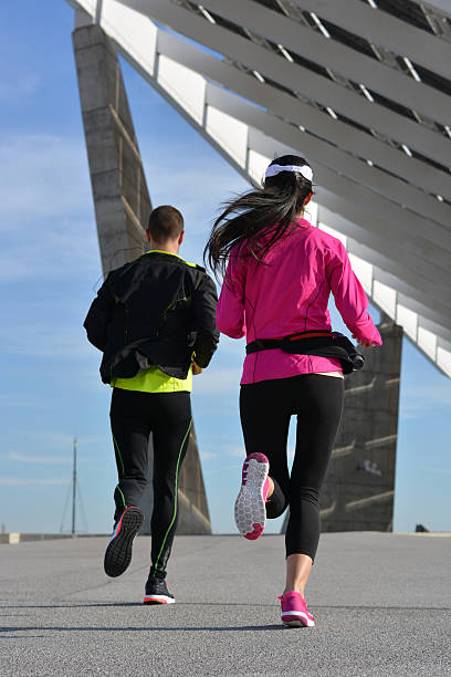 casal praticando corrida na cidade - running jogging women marathon - fotografias e filmes do acervo