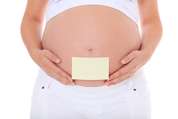 istock Pregnant woman with note on baby bump 499743648
