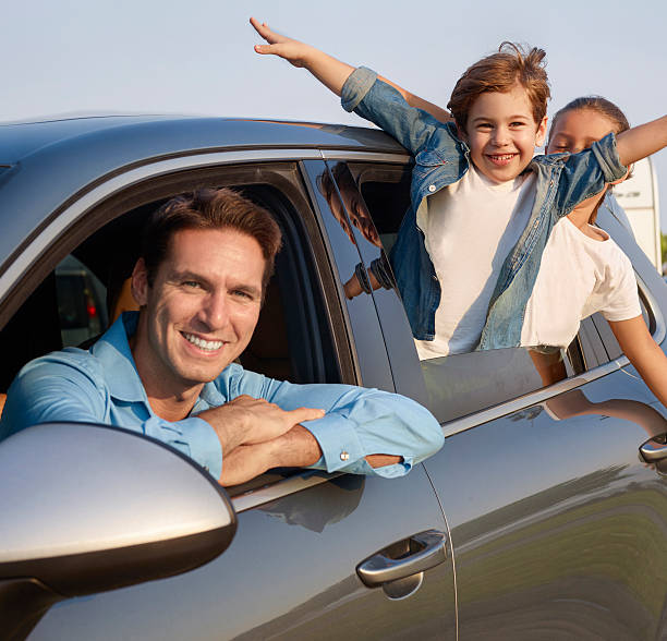 istock Happy family leaning out car windows 499743692