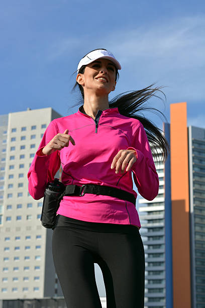 mulher praticando corrida na cidade - running jogging women marathon - fotografias e filmes do acervo