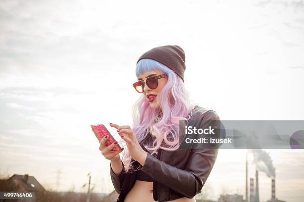 Outdoor Portrait Of Bluepink Hair Cool Girl Texting On Phone Stock Photo - Download Image Now
