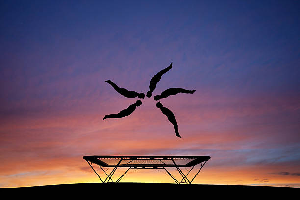 silhouetted trampoline gymnast stock photo