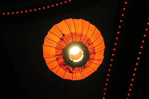 Bottom view of orange paper lantern with Christmas decorations