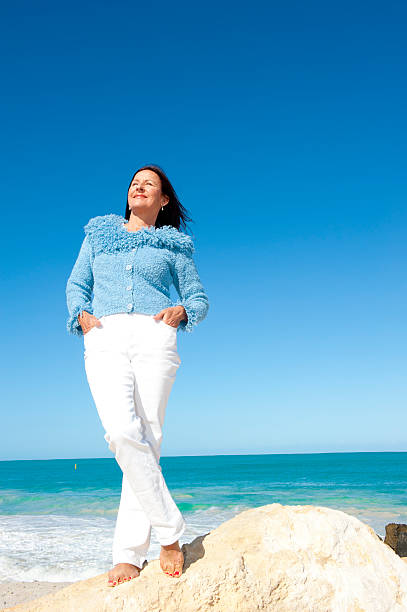 istock Confident mature woman ocean background 499751484