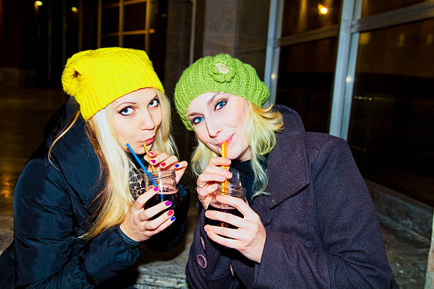 istock Beautiful Blonde Young Woman Drinking Outdoors at Night 499751616