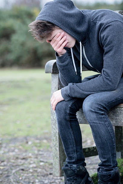 Sad Teenage Boy Sitting on A Bench
