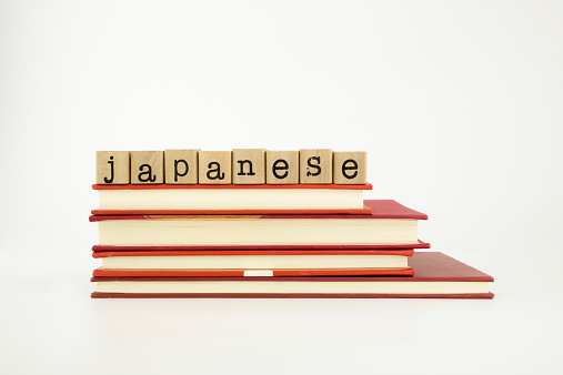 Japanese word on wood stamps stack on books, language and academic concept