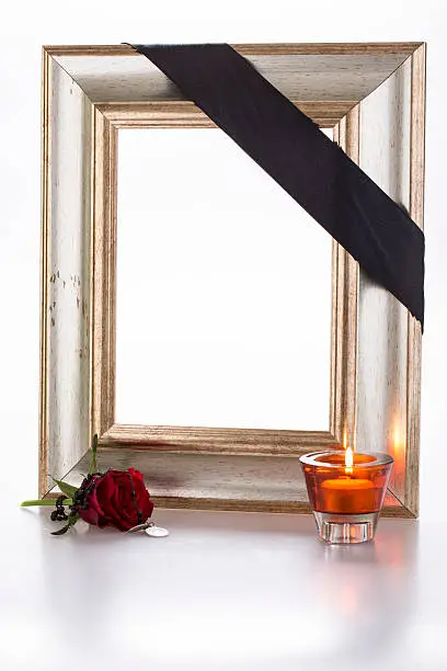gold frame with candlelight, sympathy rose, and rosary