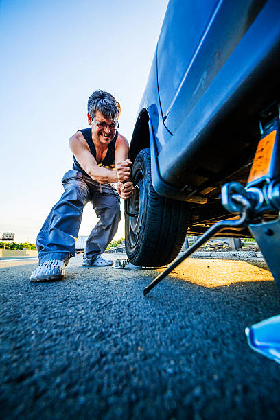 istock Man changing the flattened tyre at the highway 499760543