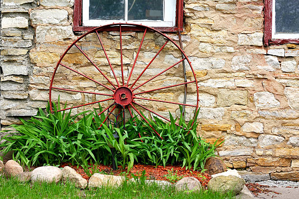 vecchio ruota di carro davanti stone barn - iron sheik foto e immagini stock