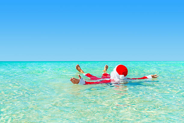 santa claus nadar no oceano de água, conceito de natal - christmas beach sun tropical climate imagens e fotografias de stock