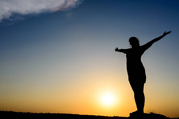 istock Woman embracing the sunrise or sunset 499775378