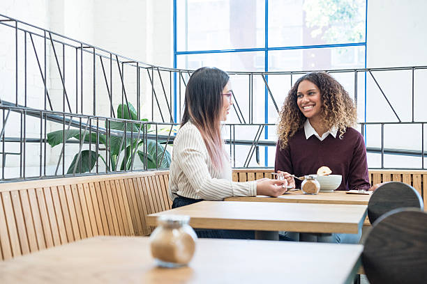istock Two businesswomen in modern cafe relaxing on coffee break 499776616
