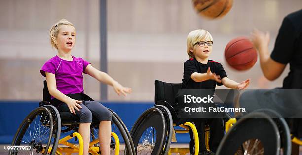 Children In Wheelchairs Passing Basketballs Stock Photo - Download Image Now - Wheelchair, Child, Sport