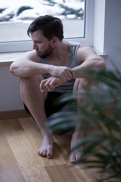 istock Sad man sitting on the floor 499779290