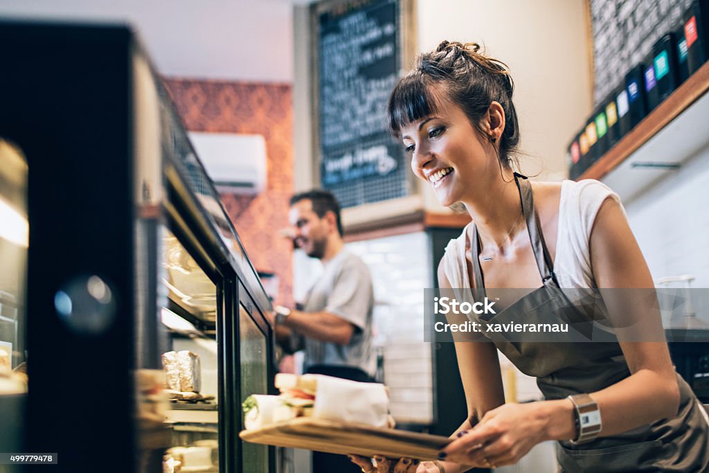 Preparing the food display Owner getting ready the food display for the clients at a coffee shop. Cafe Stock Photo