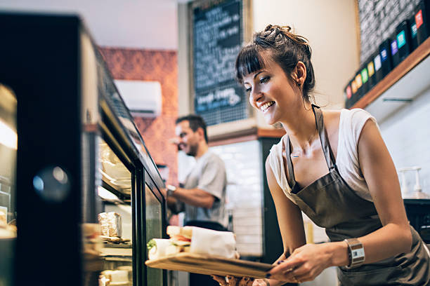 Preparing the food display Owner getting ready the food display for the clients at a coffee shop. serving food and drinks stock pictures, royalty-free photos & images