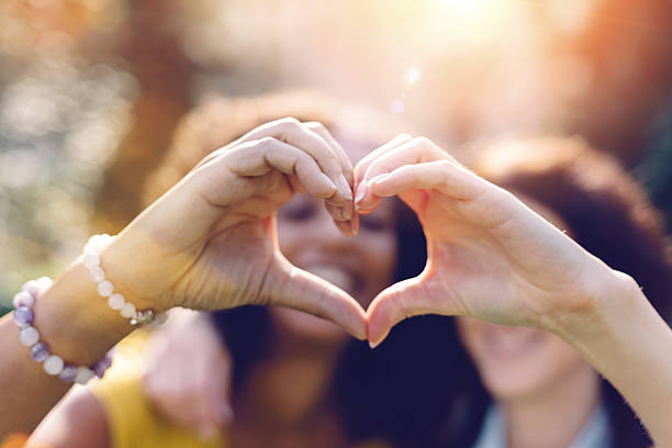 istock Mixed race girls making heart symbol with hands 499781180
