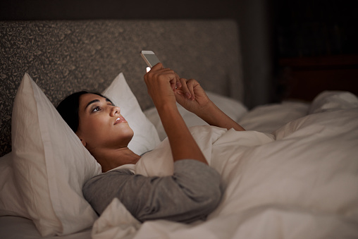 A young woman sending a text message while in bedhttp://195.154.178.81/DATA/i_collage/pi/shoots/783514.jpg