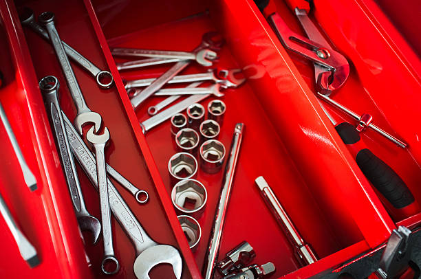 réparateur rouge boîte à outils avec une clé tenue - adjustable wrench expertise work tool maintenance engineer photos et images de collection