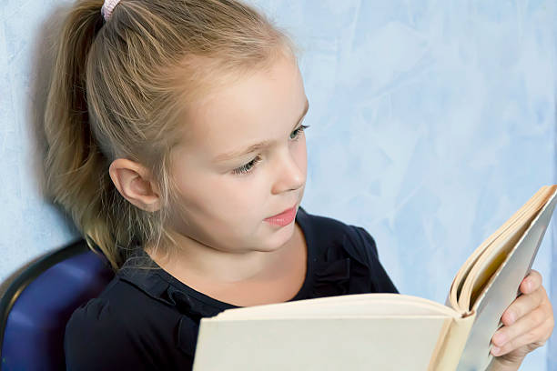 istock Cute girl reading a book 499783419
