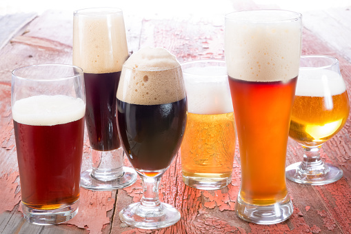 Variety of different beers, of different colors and alcoholic strengths in different shaped glasses suited to different personalities