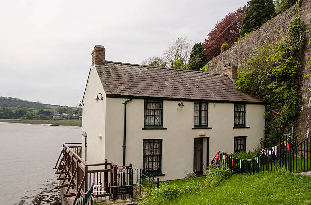 Dylan Thomas, Boat House Laugharne, UK - May 5, 2014: View of the Boat House, former home of the great Welsh poet and playwright Dylan Thomas and now preserved as a museum overlooking the Taf estuary in Laugharne, South Wales. named animal stock pictures, royalty-free photos & images