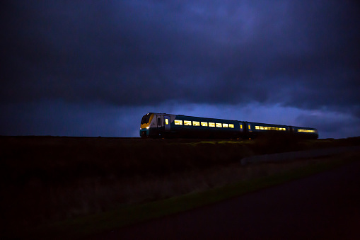 Train travelling at speed by moonlight