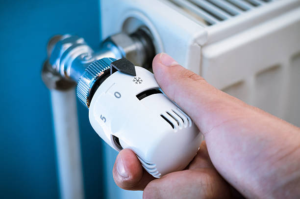 One hand adjust thermostat valve close up stock photo