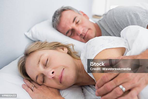 Calm Couple Sleeping And Spooning In Bed Stock Photo - Download Image Now - 40-49 Years, 50-59 Years, Adult