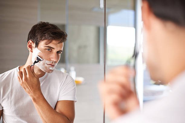 Getting the closest shave possible Shot of a reflection in the mirror of a man shaving his facial hairhttp://195.154.178.81/DATA/i_collage/pi/shoots/783523.jpg shaving stock pictures, royalty-free photos & images