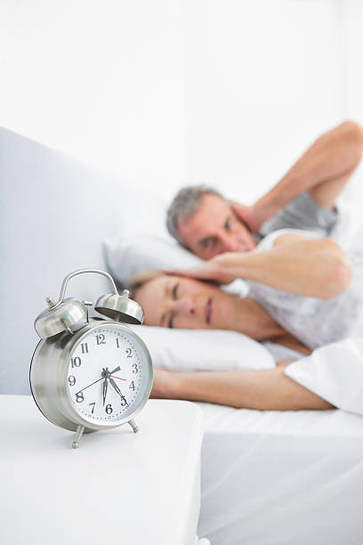 istock Couple blocking their ears from alarm clock noise 499806845