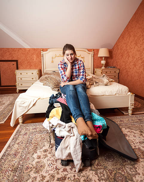 istock depressed woman sitting on unpacked suitcase 499806953