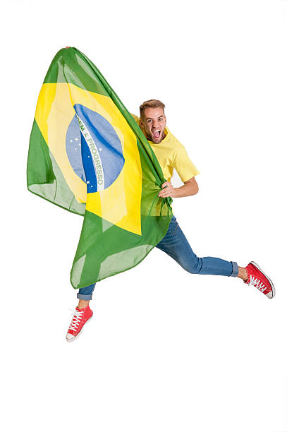 young attractive brazil supporter jumping with Brazil flag stock photo