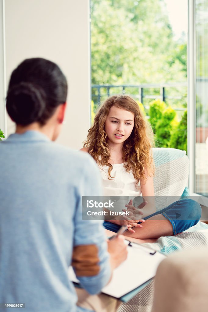 Visit a psychologist Teenager girl talking with psychologist at home. Psychotherapy Stock Photo