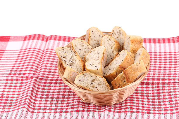 istock Wicker basket full of bread on tablecloth. 499808945