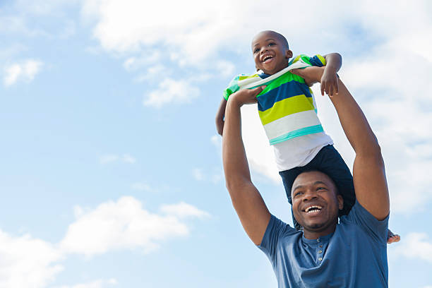 istock African son on father's shoulders at the beach 499809427