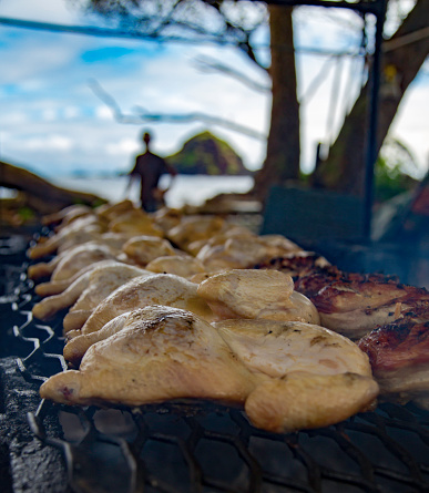 Huli Huli chicken being barbecued on an outdoor grill at Koki Beach on the island of Maui in Hawaii.Huli Huli chicken being barbecued on an outdoor grill at Koki Beach on the island of Maui in Hawaii.