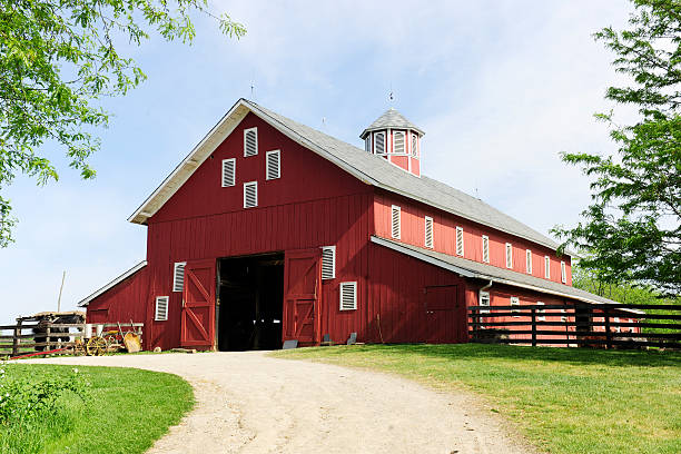 Trail to the Big, Red Barn A springtime image taken on the trail leading to the open doors of a big red barn on a sunny day. barn stock pictures, royalty-free photos & images